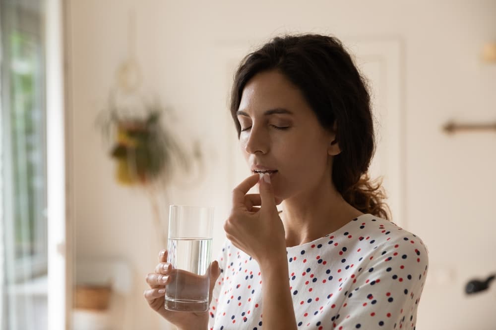 Eine Frau, die Sumatriptan-Tabletten einnimmt.
