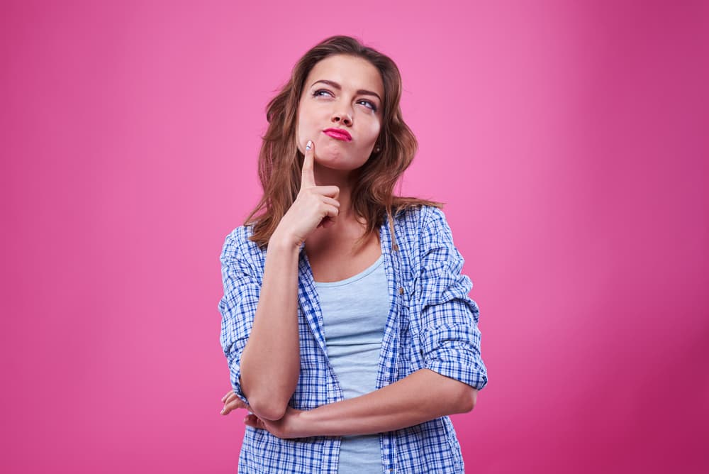 Eine Frau, die neugierig in den Himmel blickt und tief in Gedanken versunken ist