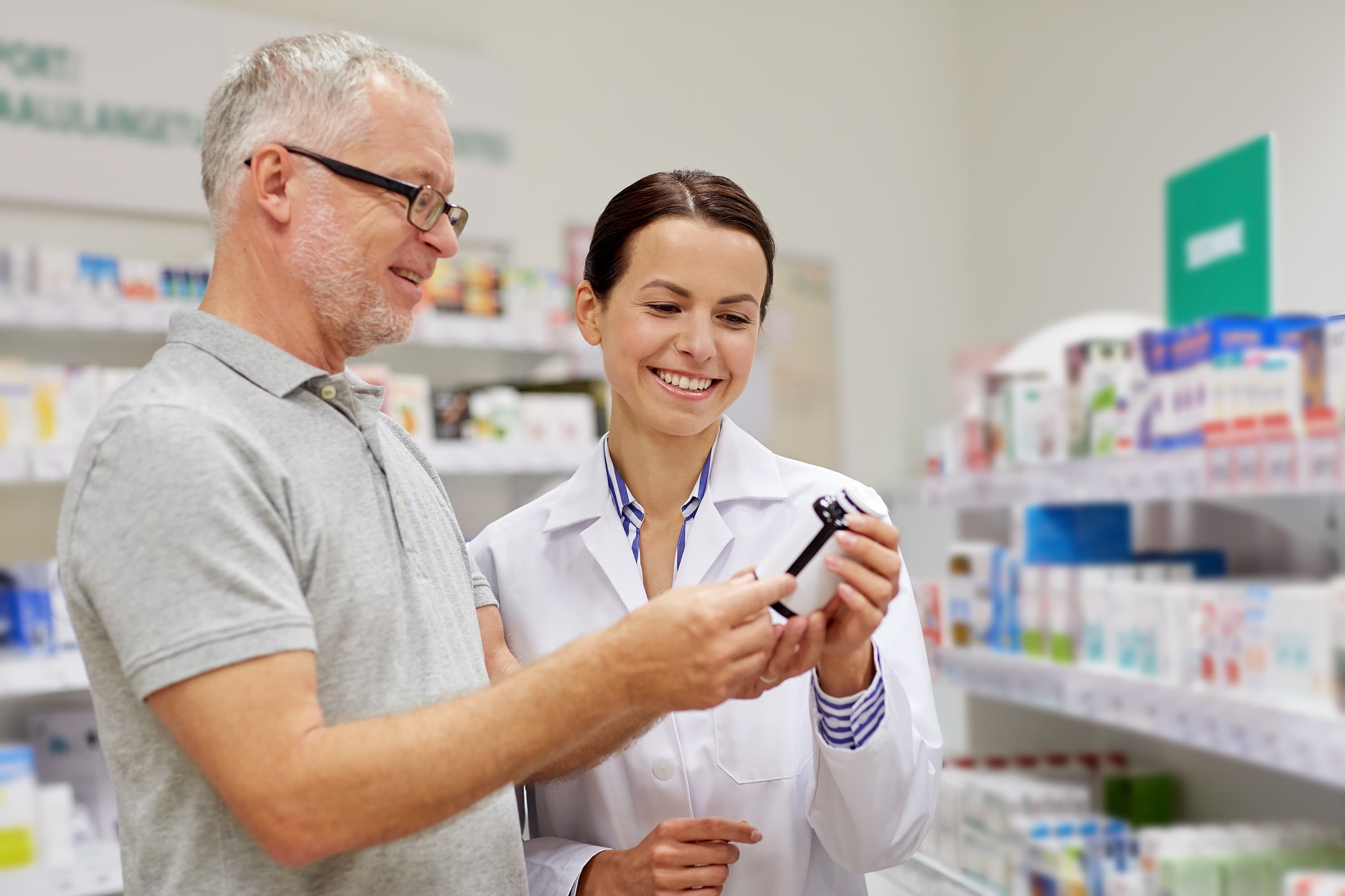 Ein Arzt und ein Patient sehen sich gemeinsam ein Medikament in einer Apotheke an