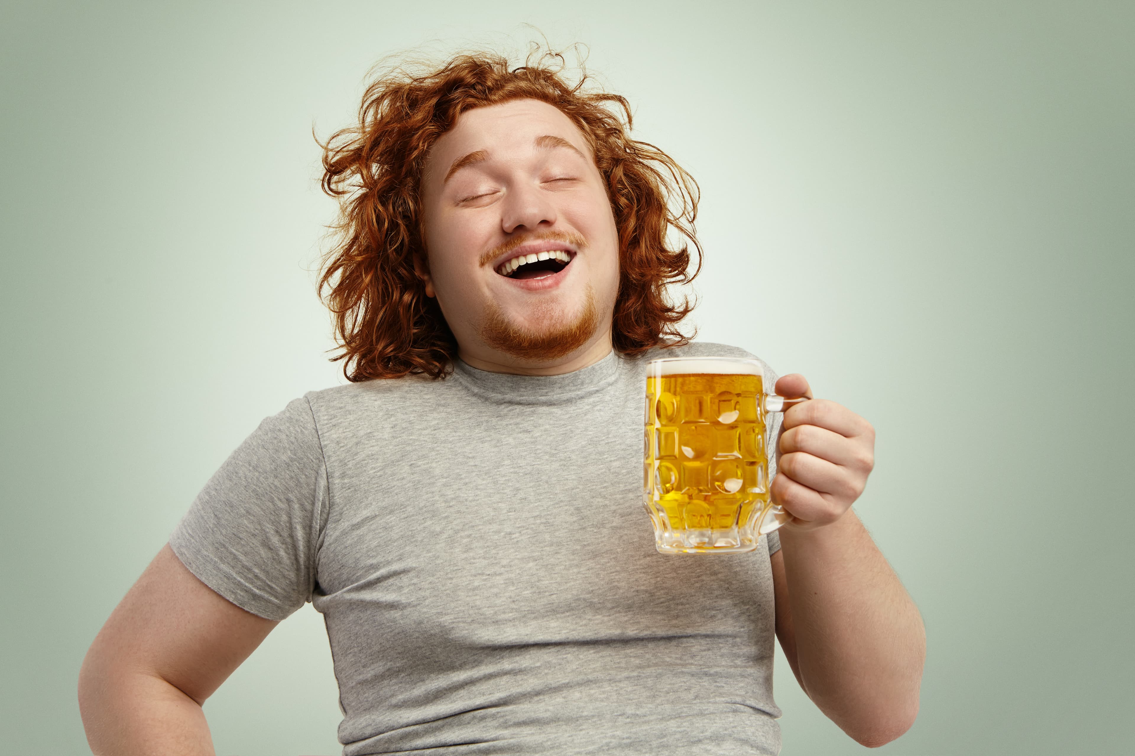 Ein glücklich aussehender Mann mit einem Glas Bier in der Hand