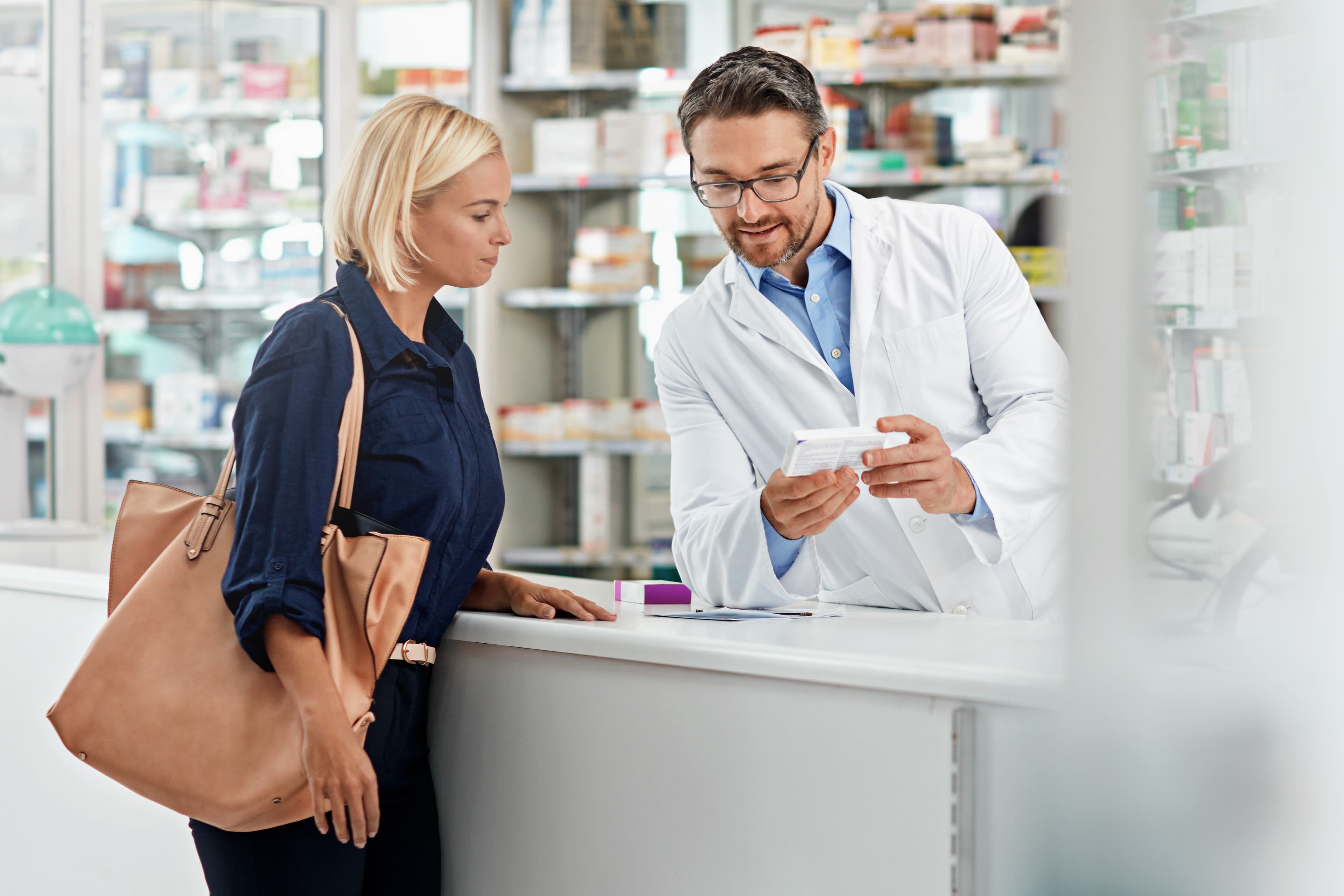 Ein Patient berät seinen Apotheker in einer Apotheke.