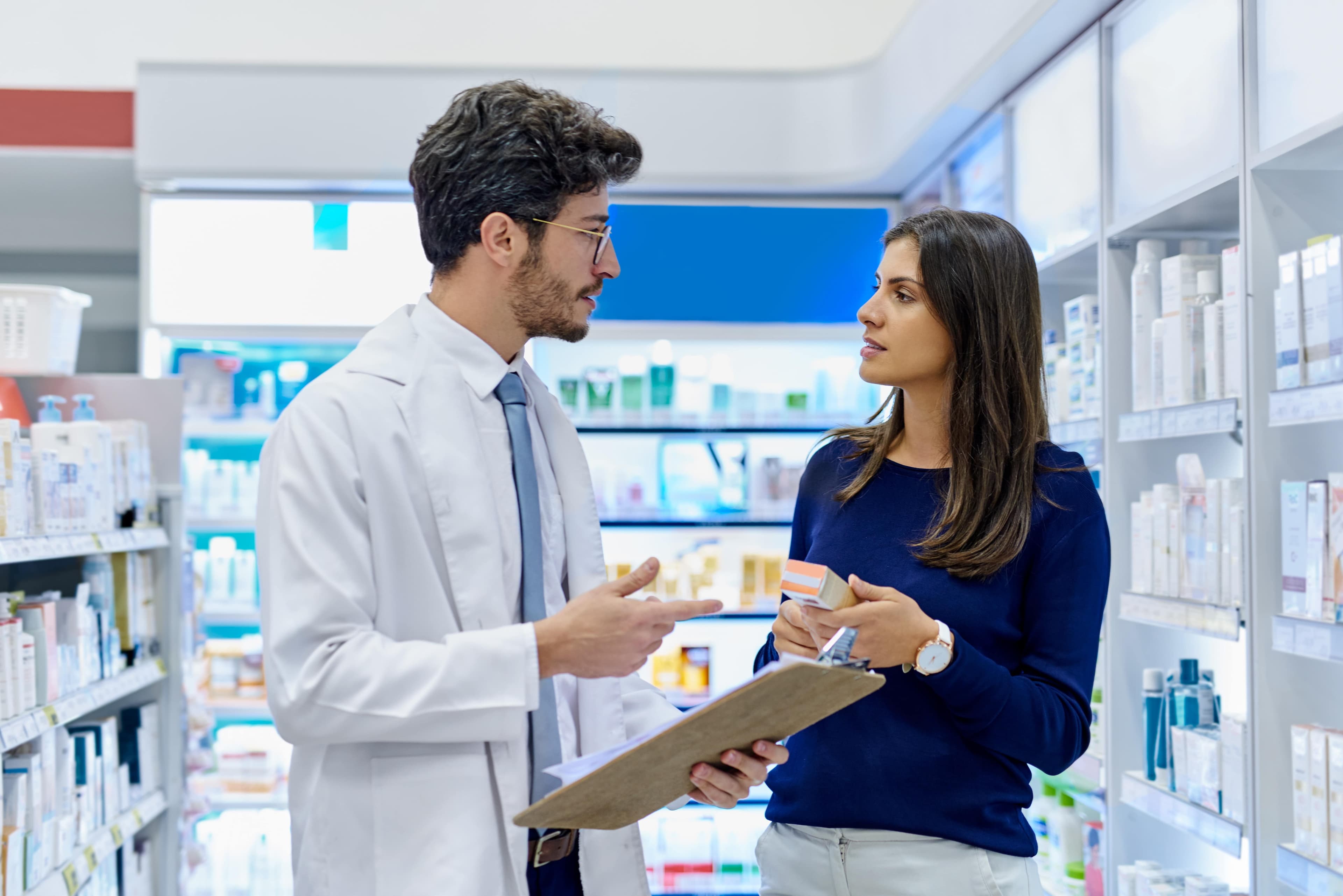 Ein Apotheker berät einen Patienten in einer Apotheke.