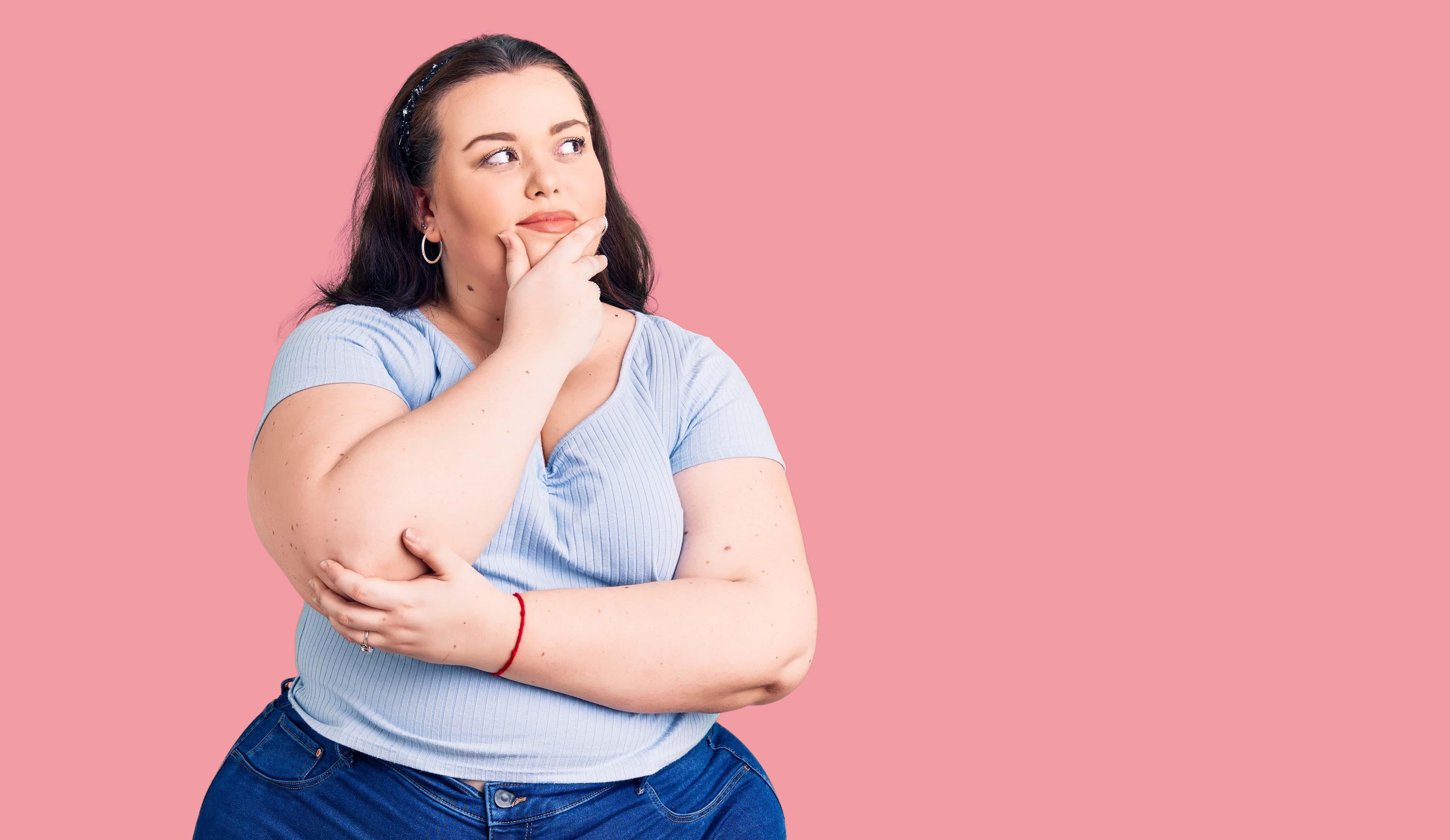 Eine übergewichtige Frau stand nachdenklich da und hatte einen neugierigen Gesichtsausdruck.