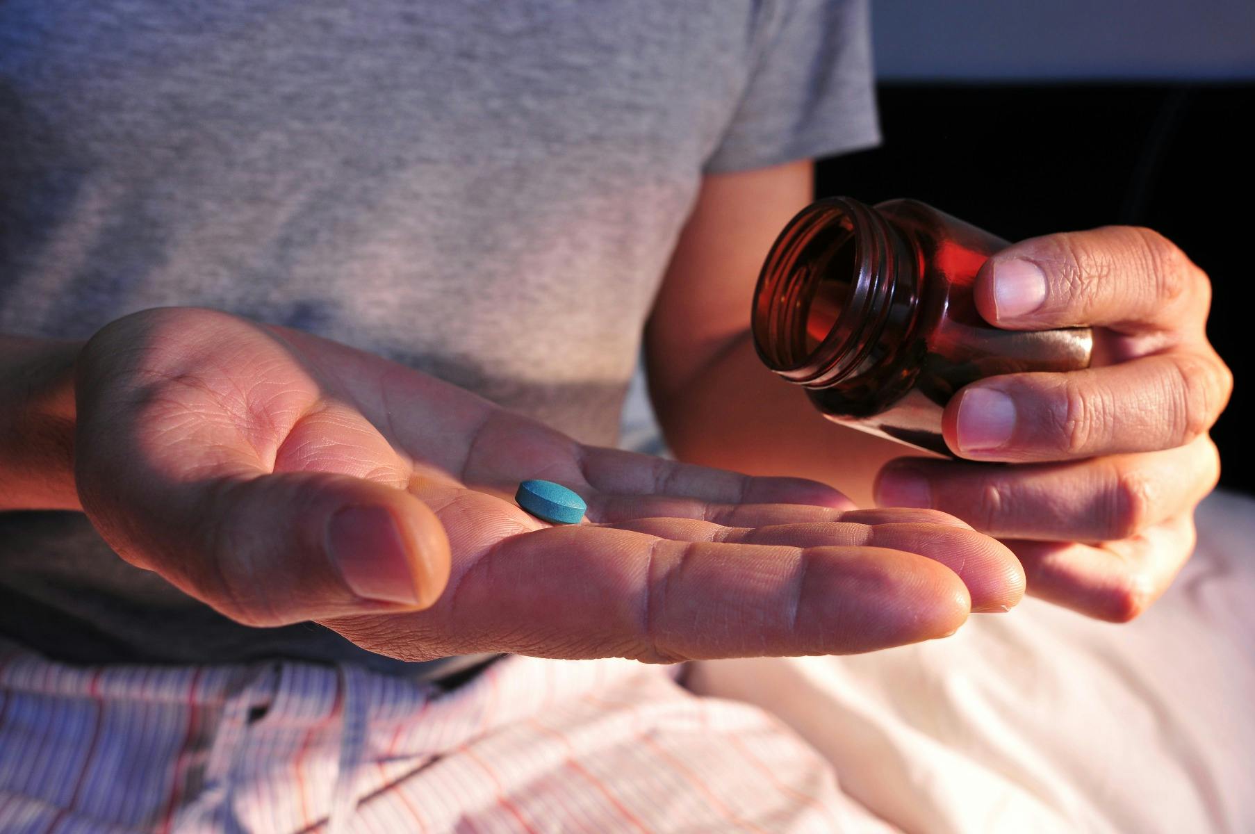 Viagra-Pille (die blaue Pille) wird aus einer Flasche in die Handfläche gegossen